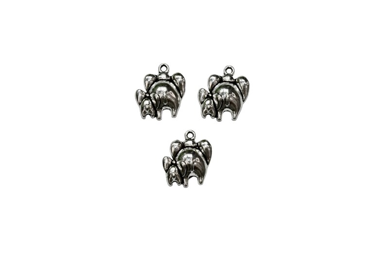 May include: Three silver charm pendants in the shape of elephants. Each elephant is standing with its trunk raised and has a smaller elephant standing behind it.