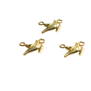 May include: Three gold-coloured genie lamp charms with a loop for attaching to a necklace or bracelet.