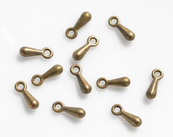 May include: A group of 12 antique gold teardrop shaped metal charms with a loop at the top.