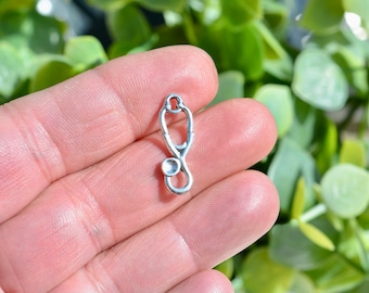 Puede incluir: Encanto de metal plateado en forma de estetoscopio. El encanto es una opción popular para la elaboración de joyas y proyectos de artesanía.