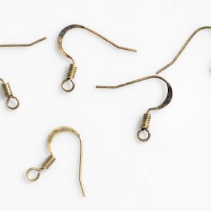 May include: Five gold-toned earring hooks with spring closures. The hooks are made of metal and have a smooth finish.