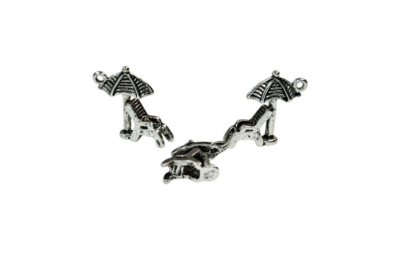 May include: Three silver charm pendants in the shape of a beach chair with an umbrella. The charms are perfect for adding a summery touch to jewelry.