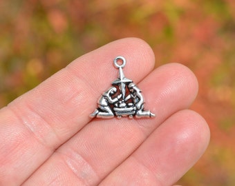 May include: Silver charm depicting the nativity scene with Mary, Joseph, and baby Jesus in a manger. A star sits above the manger.