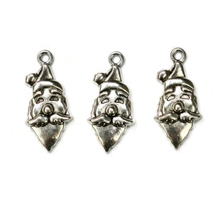 May include: Three silver-toned metal charms shaped like Santa Claus faces. Each charm has a red hat, white beard, and a smiling face.