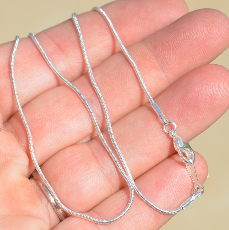 Puede incluir: Un collar de cadena de serpiente de plata con cierre de langosta.