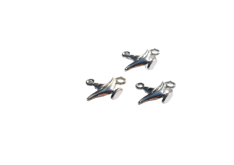 Puede incluir: Tres colgantes de plata con forma de l&aacute;mpara m&aacute;gica de Aladino. Cada colgante tiene un bucle para sujetarlo a un collar o pulsera.
