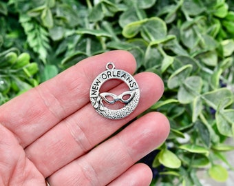May include: Silver charm featuring the words "NEW ORLEANS" and a Mardi Gras mask design.