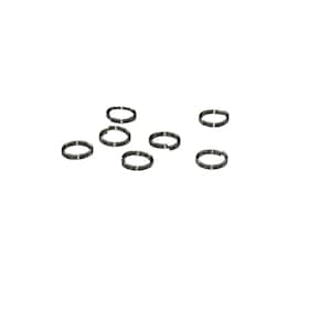 May include: A set of eight silver jump rings, all the same size, scattered on a white background.