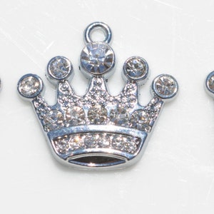 May include: Three silver crown charms with clear rhinestone accents.