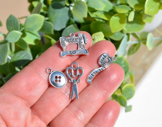 12 Mixed Piece  Sewing Set, Sewing Machine, Scissors, Tape Measure, Needle, Thread, Buttons, Silver Tone Tool Charms SC6985