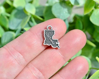 May include: Silver charm shaped like the state of Louisiana with the word "Louisiana" inscribed on it.