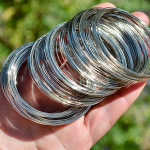 May include: A stack of silver wire rings, likely for jewelry making.