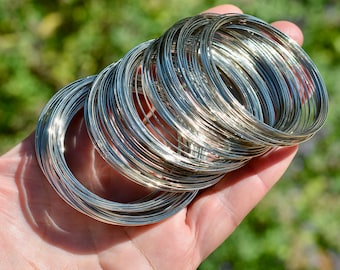May include: A stack of silver wire rings, likely for jewelry making.