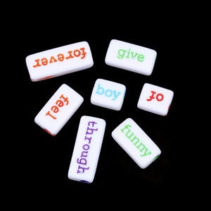 May include: White rectangular blocks with colorful words: "forever," "give," "feel," "boy," "to," "through," and "funny." The blocks are arranged in a circular pattern against a black background.