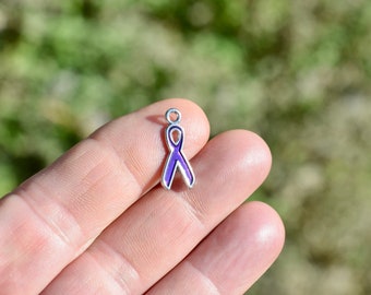 May include: A silver charm in the shape of a purple ribbon. The ribbon is a symbol of awareness for many causes.