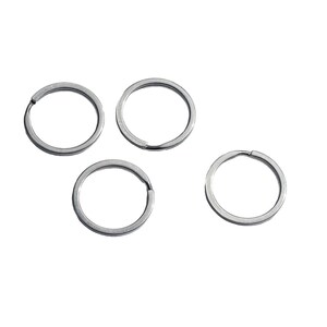 May include: Four silver key rings, each with a circular shape and a smooth, polished finish.