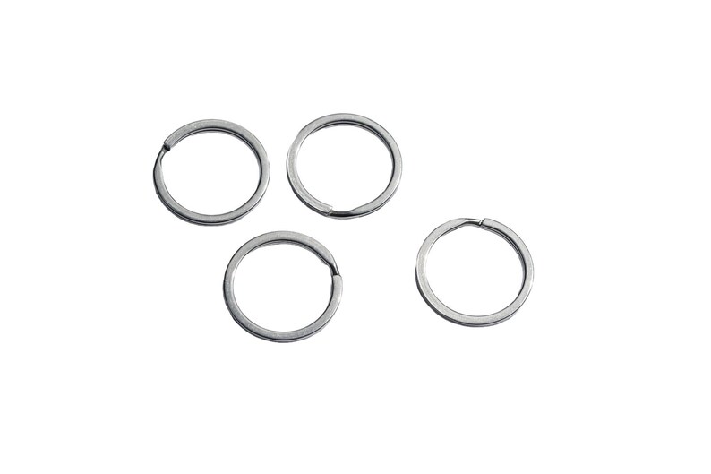 May include: Four silver key rings, each with a circular shape and a smooth, polished finish.