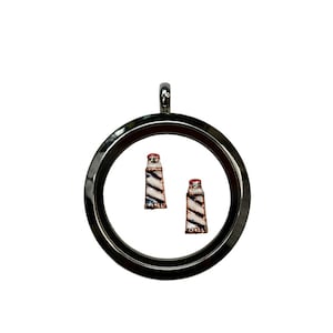 May include: A silver locket charm with two small lighthouse charms inside. The lighthouses are white with red and blue stripes.