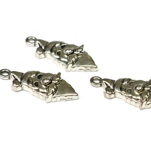 May include: Three silver-toned metal charms shaped like Santa Claus's face. Each charm has a loop at the top for attaching to a necklace, bracelet, or other jewelry.