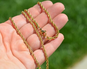May include: A gold-toned rope chain necklace with a lobster clasp.