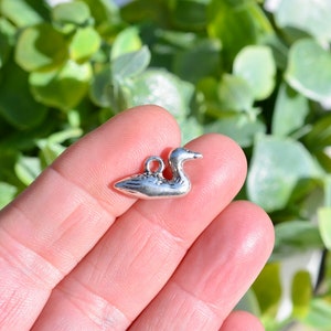 May include: Silver charm shaped like a duck, ideal for adding a touch of whimsy to jewellery or crafts.