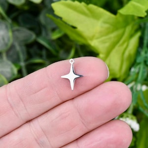 May include: A silver star charm with a hole at the top for attaching to a necklace or bracelet.