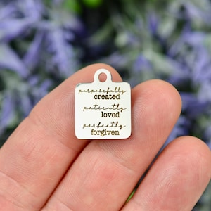 May include: Silver charm with the words "purposefully created patiently loved perfectly forgiven" engraved on it.