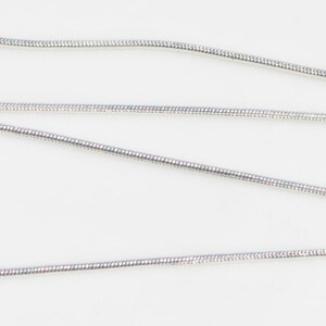 Puede incluir: Un collar de cadena de serpiente de plata con cierre de langosta.