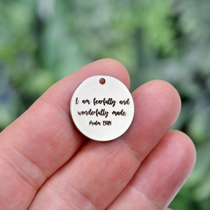 May include: A silver round charm with the text "I am fearfully and wonderfully made. Psalm 139:14" engraved on it.