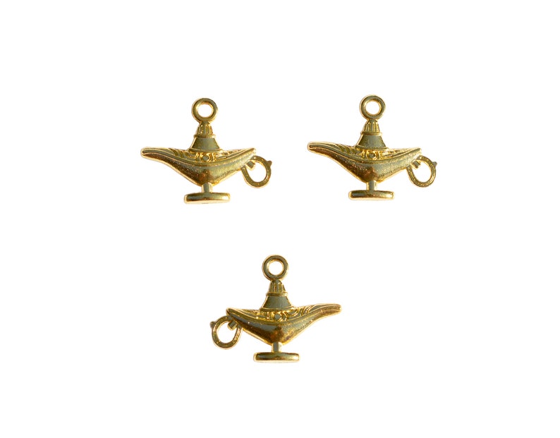 May include: Three gold-coloured genie lamp charms with a loop for hanging. The lamps are detailed with intricate designs.