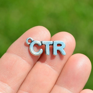 May include: Silver charm with the letters CTR, a popular abbreviation for click-through rate, a key metric in digital marketing.