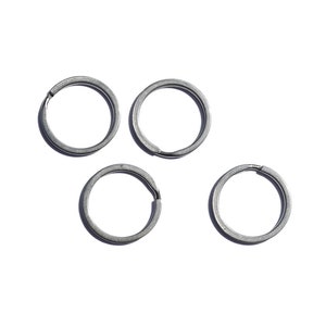 May include: Five silver key rings, all the same size and shape, are arranged in a triangular pattern on a white background.
