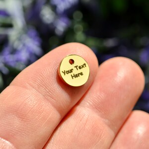 Op de afbeelding: Een gouden metalen schijf met de tekst "Your Text Here" erop gegraveerd.