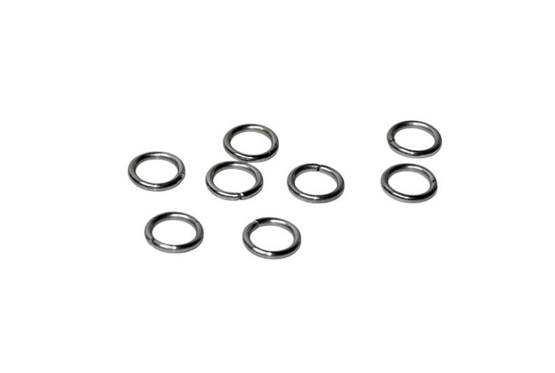 Op de afbeelding: Een verzameling van zeven kleine, ronde metalen buigringen. Elke ring heeft een gladde, donkergrijze afwerking en een enkel zichtbaar snijpunt langs de omtrek, wat aangeeft dat ze zijn ontworpen voor het verbinden van sieradenonderdelen.