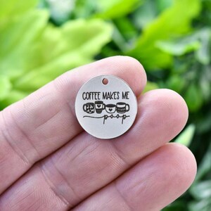 May include: Silver charm with the text "Coffee makes me poop" and a row of coffee cups with hearts.