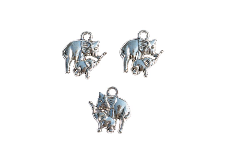 May include: Three silver charm pendants featuring a mother elephant and baby elephant. The elephants are facing right and the baby elephant is standing on the mother's foot.
