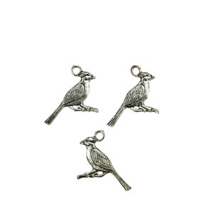 K&ouml;nnte beinhalten: Drei silberne Vogel-Anh&auml;nger aus Metall, jeder zeigt einen Kardinal, der auf einem Ast sitzt. Die Anh&auml;nger haben oben eine Schlaufe zum Anbringen an Schmuck oder anderen Bastelarbeiten.