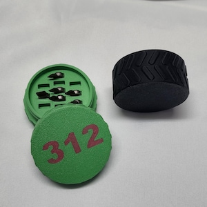 May include: Green and black three-piece grinder with a black rubber bottom and a green top with the number 312 printed on it.