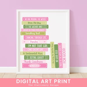 May include: A framed digital art print with a stack of book spines in pink, green, and white, each bearing musical theatre quotes. The words "DIGITAL ART PRINT" and "The Stationery Escape" are at the bottom.