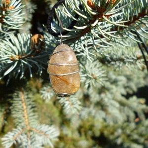 May include: A gold and clear quartz crystal pendant wrapped in silver wire, hanging from a black cord.