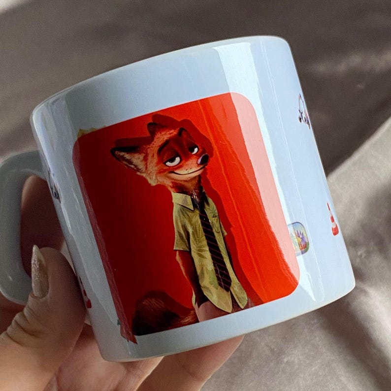 May include: A white ceramic mug featuring a printed graphic of a cartoon fox character with orange fur, wearing a light green short-sleeved button-down shirt and a dark striped tie, set against a vibrant red background on the side of the mug.