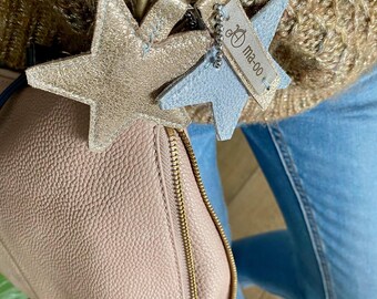 May include: A gold and light blue star-shaped leather keychain with a gold metal ring and a tag that says "Ma-oo".