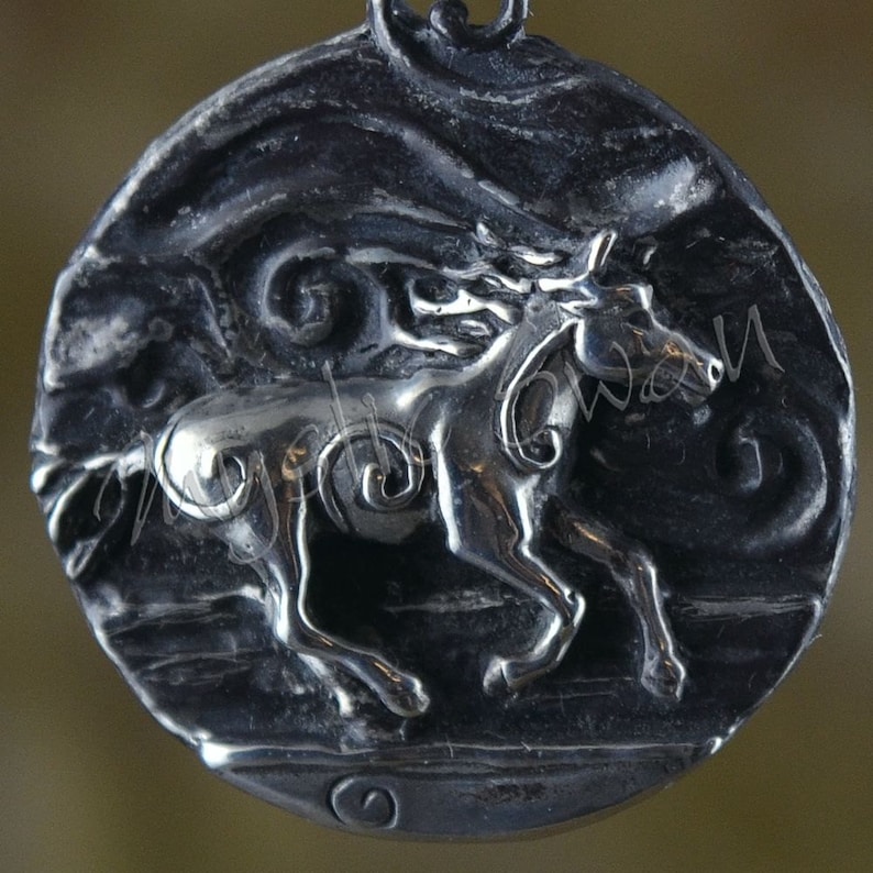 Puede incluir: Un colgante de plata con una escultura tridimensional detallada de un caballo corriendo. El caballo est&aacute; representado en una pose din&aacute;mica con su crin ondeando en el viento. El colgante tiene un acabado texturizado y envejecido.