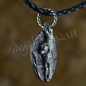 Puede incluir: Un collar con un colgante de plata con un dise&ntilde;o detallado de una ardilla trepando a un &aacute;rbol. El colgante tiene forma ovalada y una superficie texturizada.