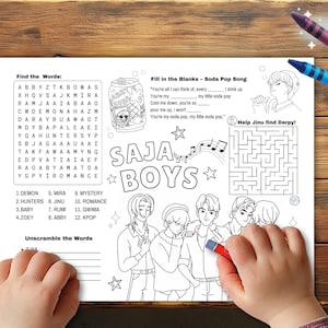 Op de afbeelding: Een zwart-wit kleurplaat met de tekst "SAJA BOYS" en diverse activiteiten, waaronder een woordzoeker, invuloefeningen en een doolhof. Een kinderhand houdt een rode kleurpotlood vast.