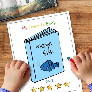 May include: A child's drawing of a book titled "Magic Fish" with a blue cover and a cartoon fish illustration. The words "My Favorite Book" are written above the book. A red crayon is held in a child's hand. The drawing is on a white paper.