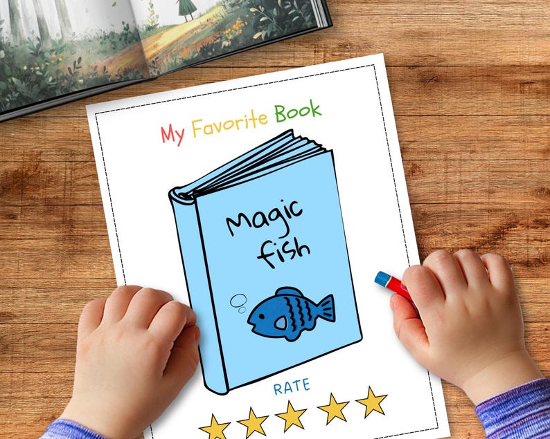 May include: A child's drawing of a book titled "Magic Fish" with a blue cover and a cartoon fish illustration. The words "My Favorite Book" are written above the book. A red crayon is held in a child's hand. The drawing is on a white paper.