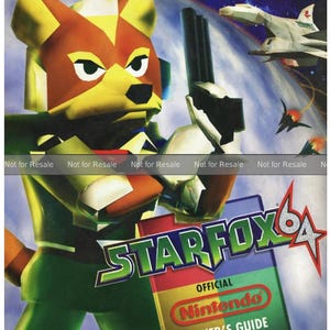 May include: A vibrant image of the Star Fox 64 Official Nintendo Player's Guide. The cover features a character holding a weapon, with a space battle scene in the background. The Nintendo Power logo is visible at the top.