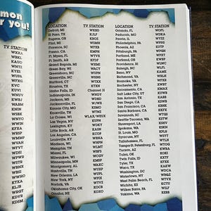 May include: A page from a book featuring a list of US cities and their associated TV stations. The list is arranged in columns, with city names on the left and station call letters on the right. The page has a blue and white design.