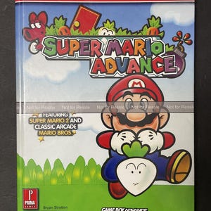 May include: A Prima's Official Strategy Guide for Super Mario Advance video game for the Game Boy Advance. The cover features a cartoon image of Mario holding a turnip. The guide includes Super Mario 2 and Classic Arcade Mario Bros.
